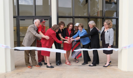resident Adela de la Torre, center holding scissors, with faculty members on right and major donors on left [Photo (c.) Ken Jacques]